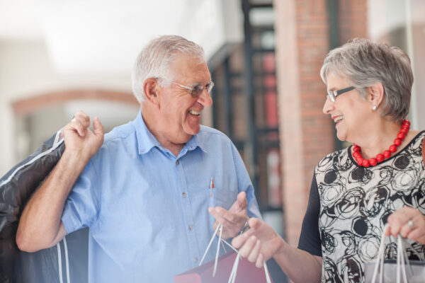 Mature Couple Walking Along Street Carrying Shopp